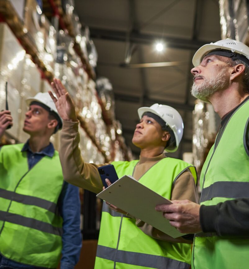 Group of workers in warehouse doing stock review storage management