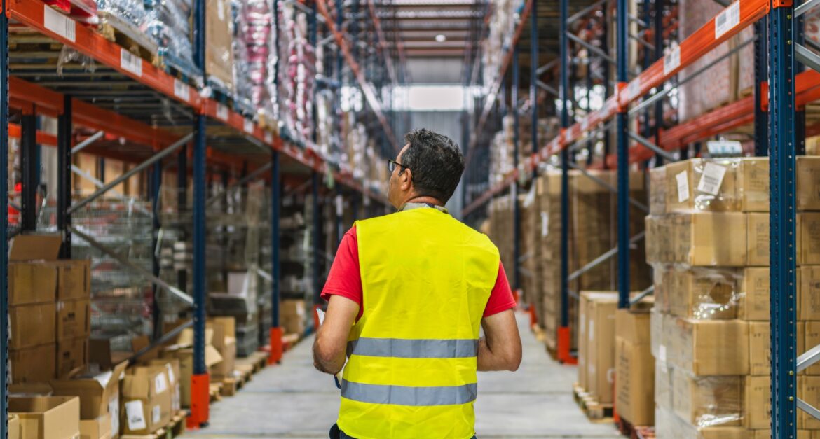 Supervisor walking and checking inventory in logistics warehouse