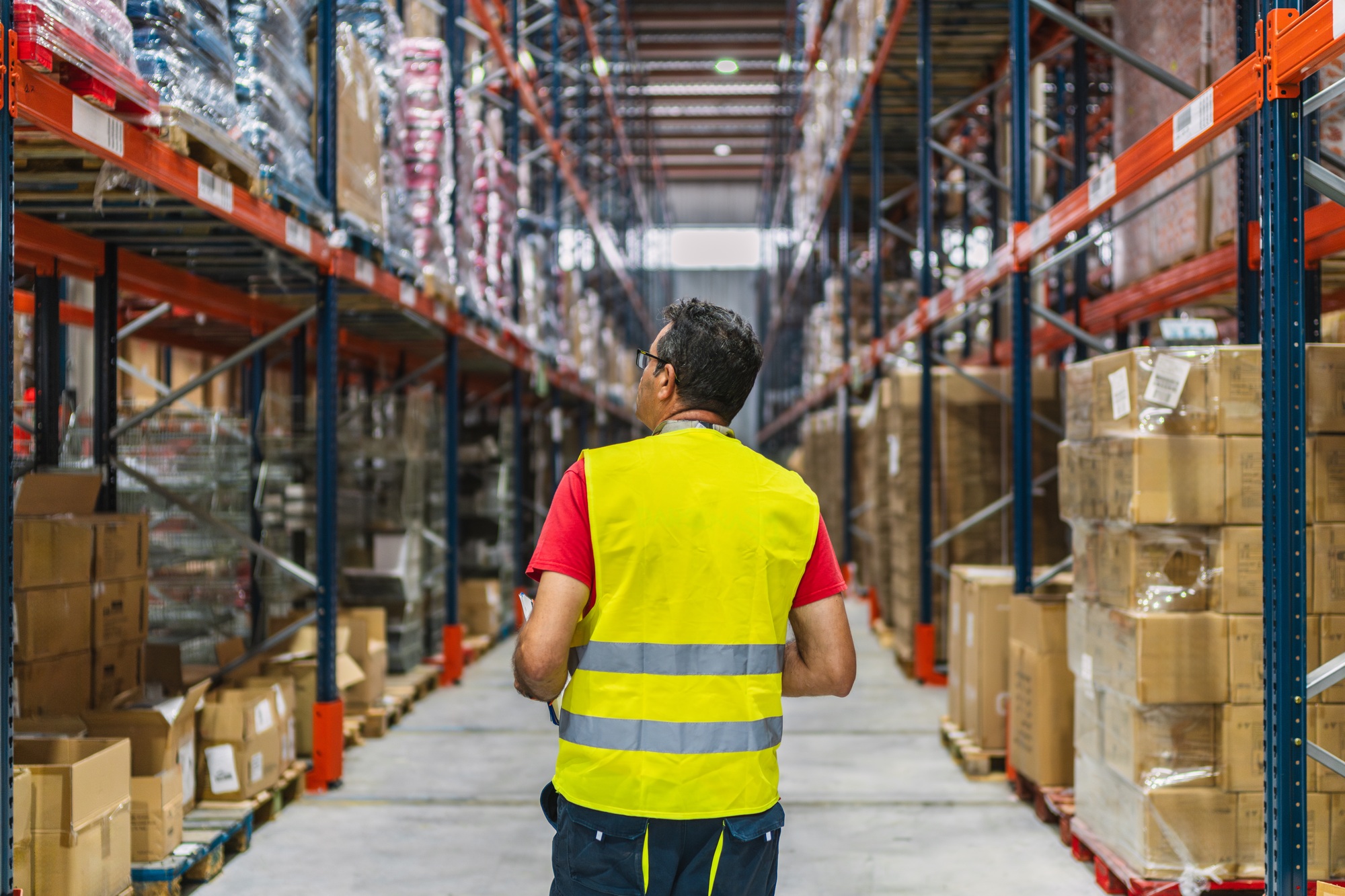 Supervisor walking and checking inventory in logistics warehouse